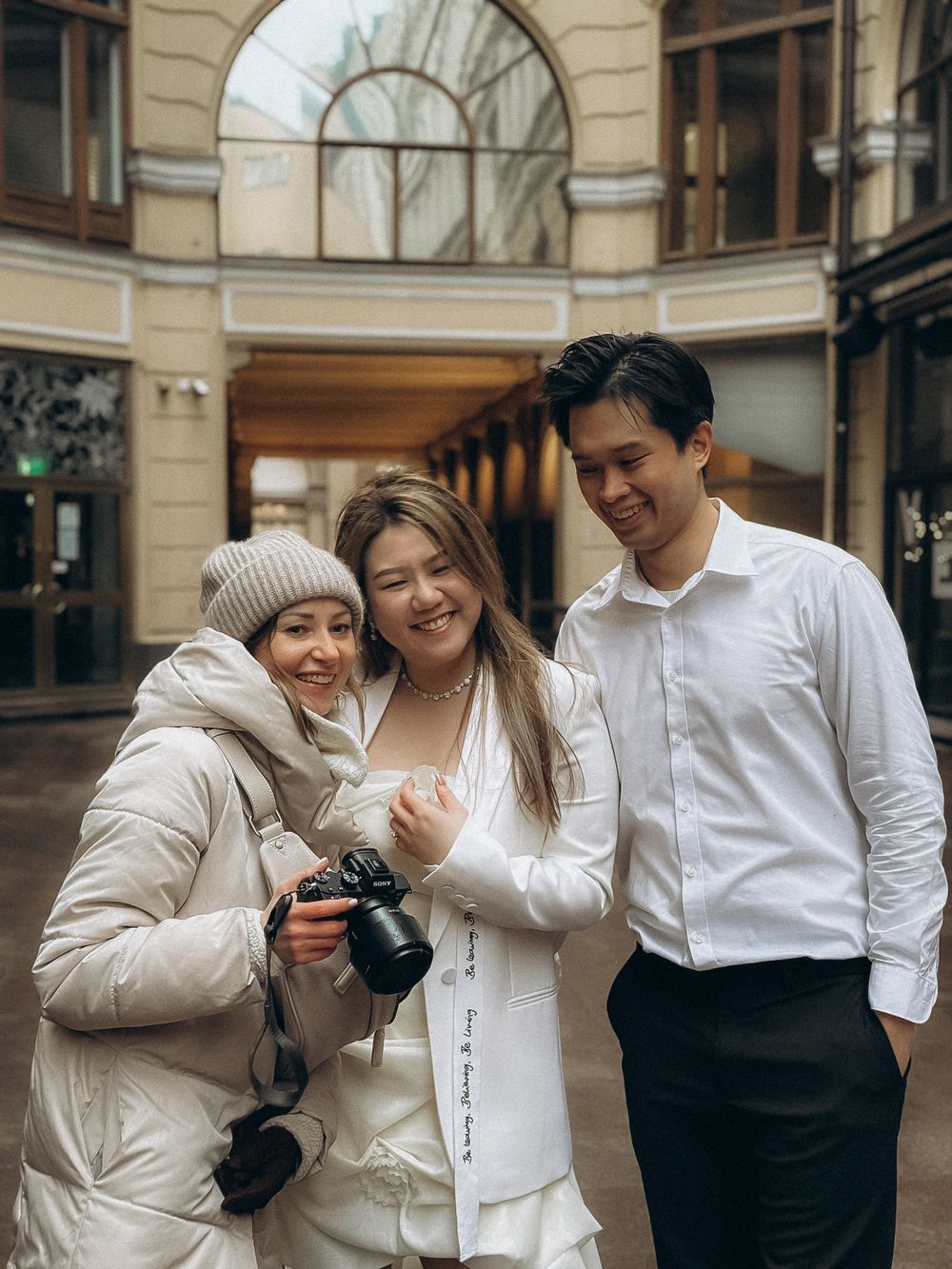 Happy engaged couple with their photographer during an engagement photoshoot in Helsinki city centre