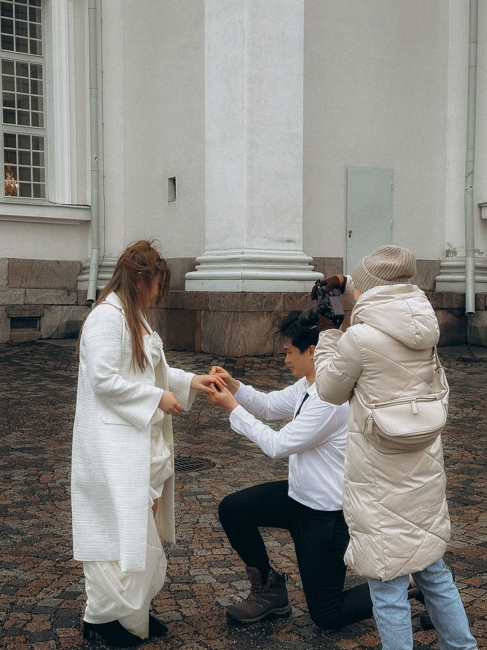 Behind the scenes of an engagement photoshoot at Helsinki Cathedral with the photographer guiding the couple