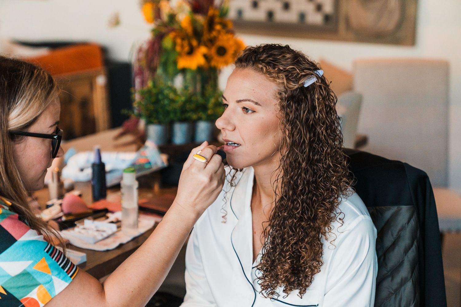 Makeup artist applying lipstick to a bride with curly hair before her wedding day. north cascades elopement wedding