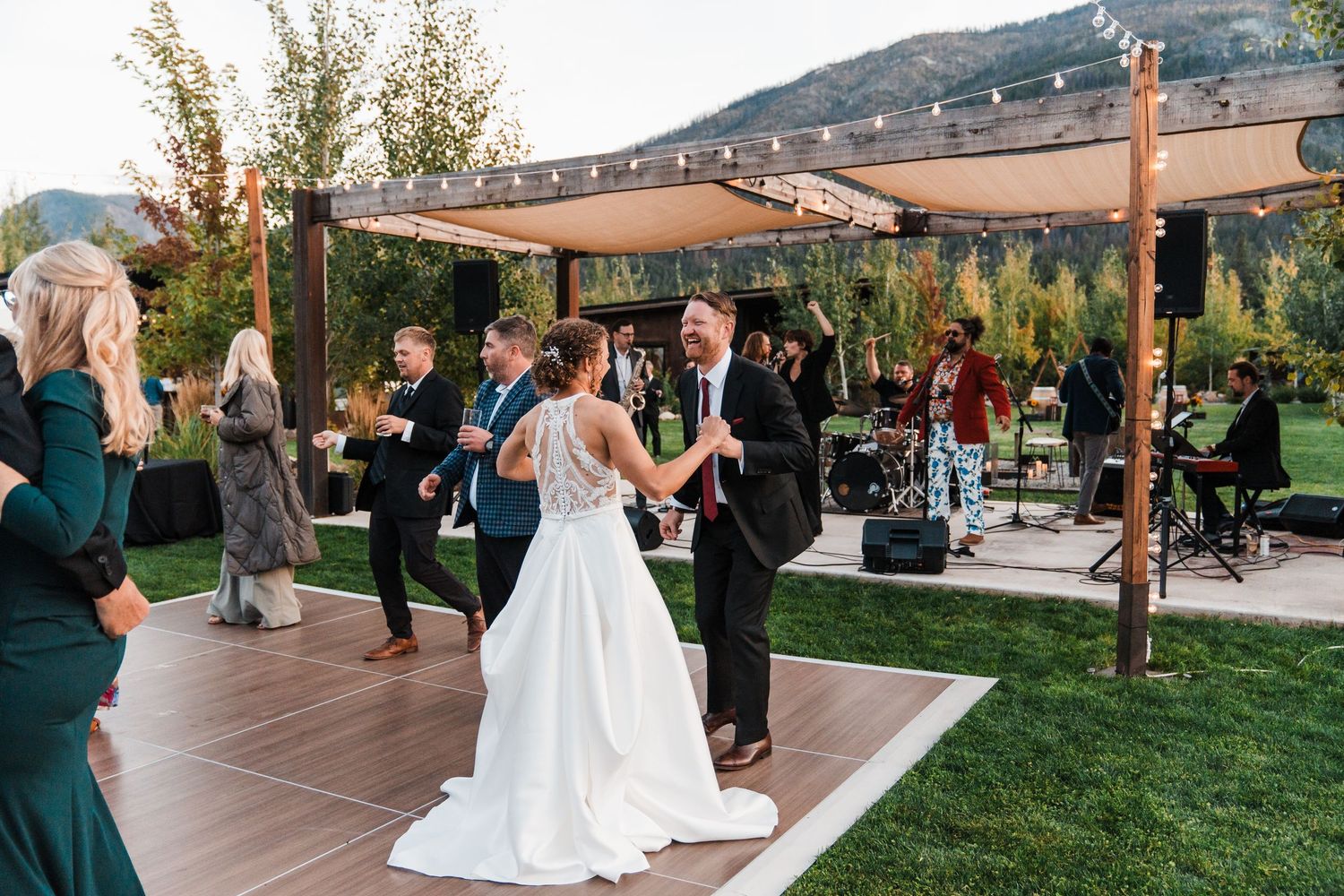 Bride and groom share first dance at outdoor mountain wedding reception with live band and string lights. north cascades elopement wedding