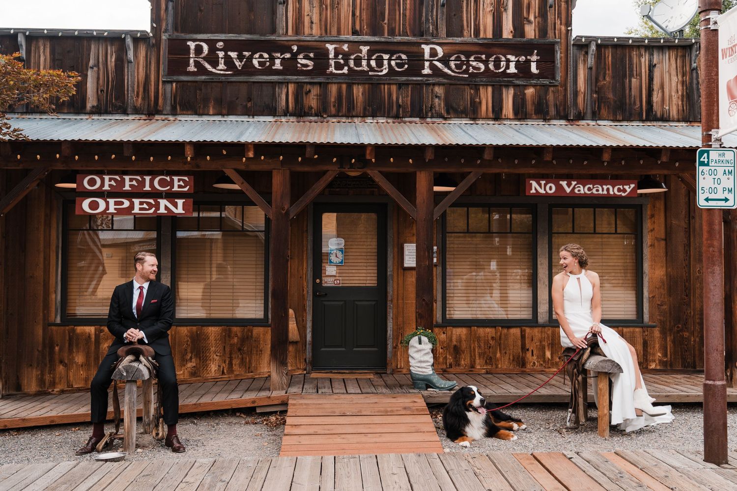 Bride and groom sit apart on rustic porch of River's Edge Resort with their Bernese Mountain Dog between them. north cascades elopement wedd
