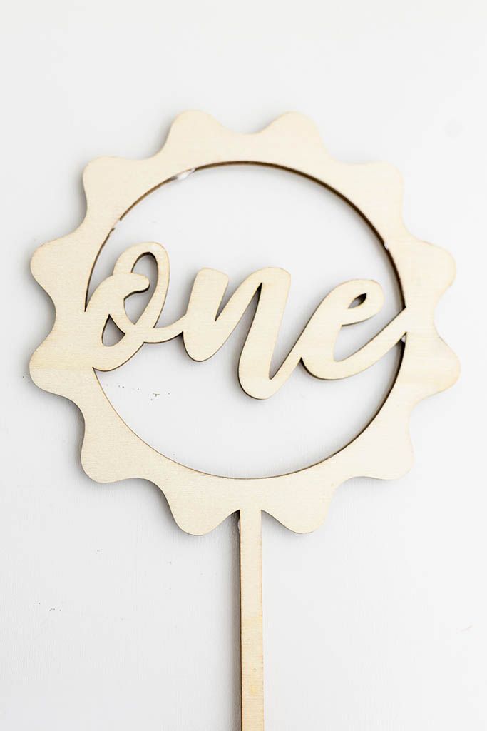 Natural wood laser cut one cake topper in circular sunflower.