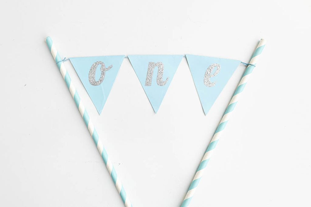 Light blue pennant banner cake topper spelling ONE.