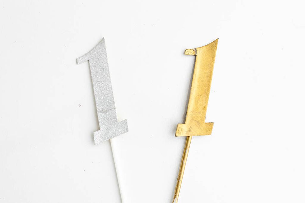 Silver and gold glitter number one cake toppers for first birthday photos.