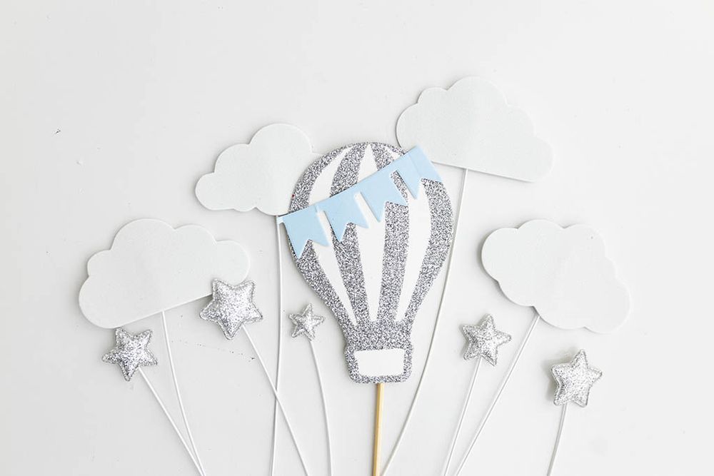 Silver glitter hot air balloon cake topper set with clouds and stars.