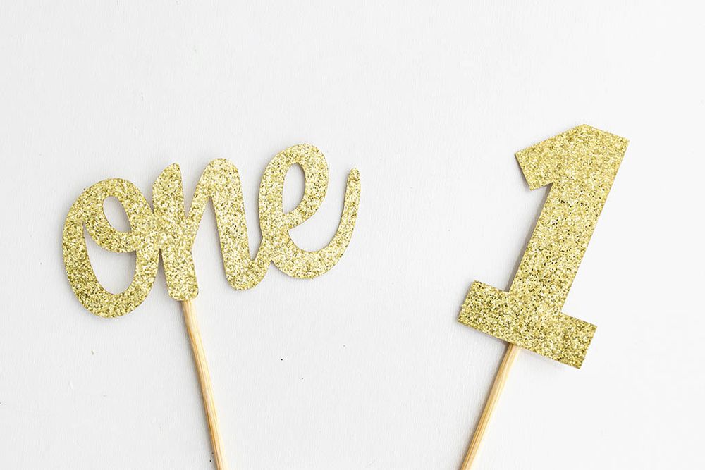 Gold glitter cake toppers for baby's first birthday professional photoshoot.