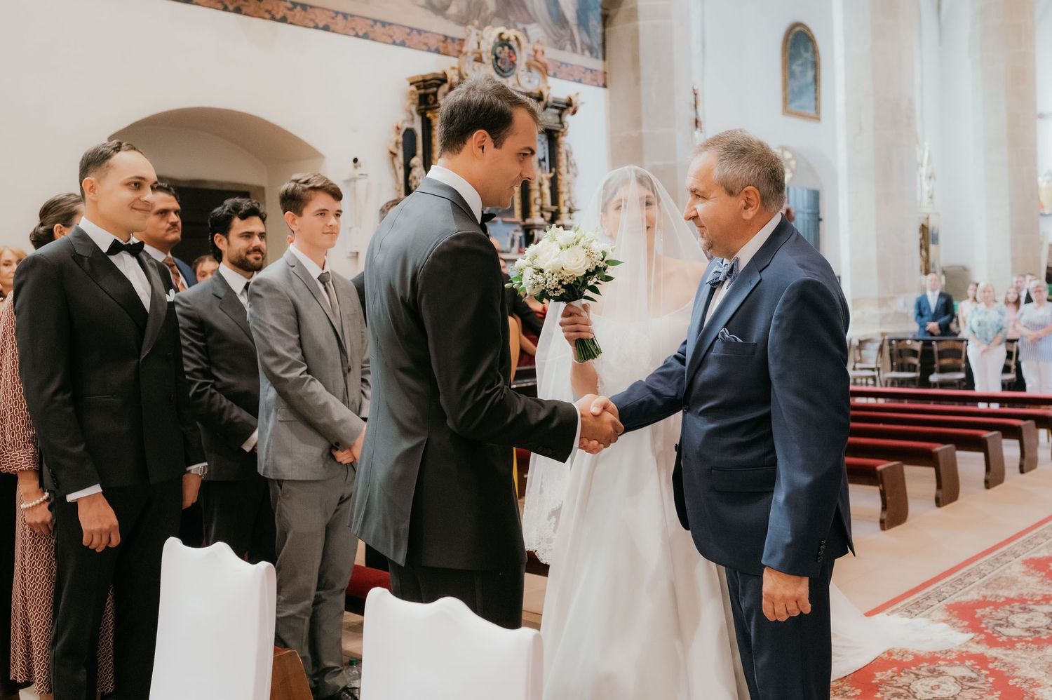 Father giving away bride to groom during traditional church wedding ceremony.