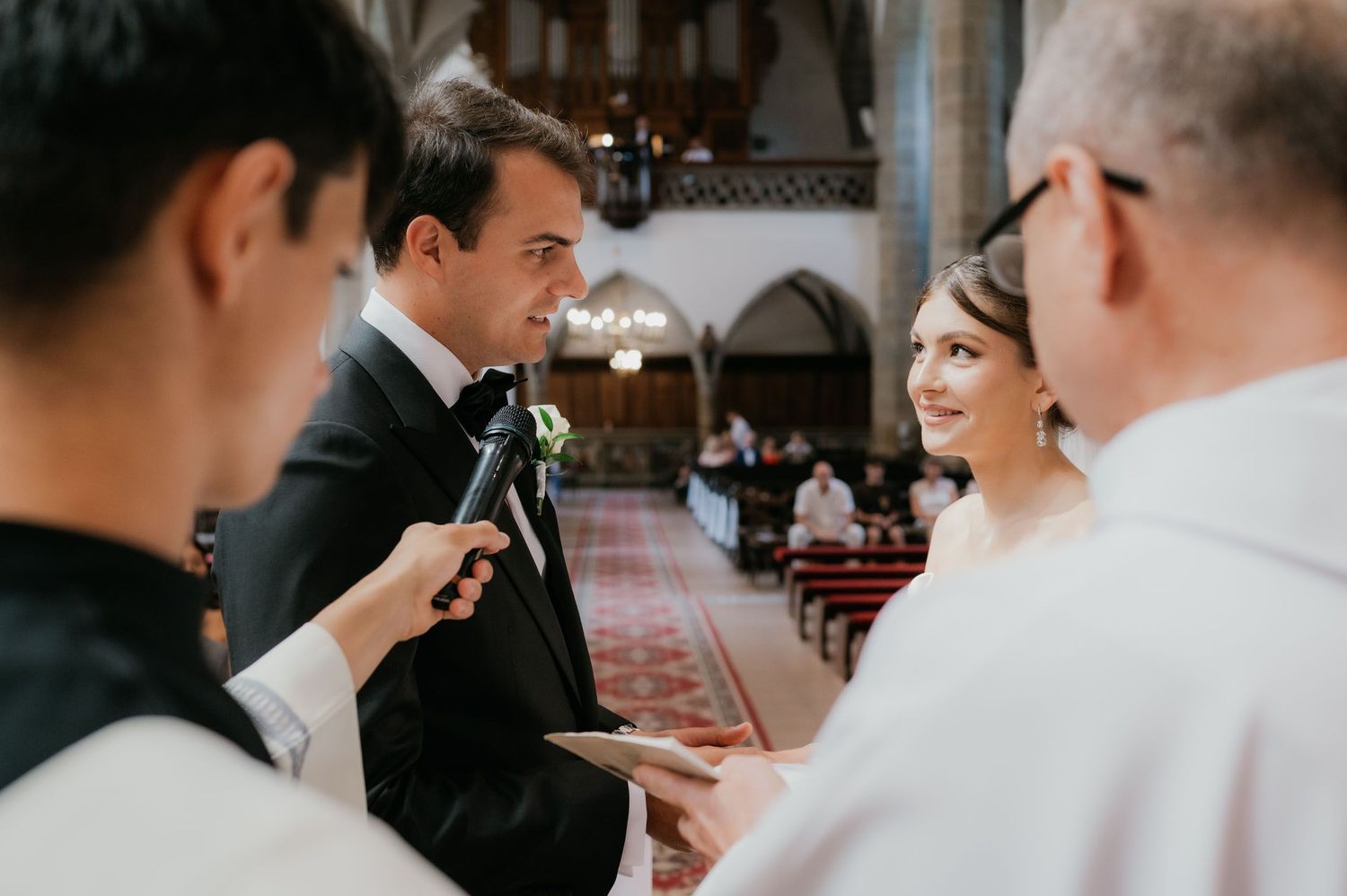 Groom reciting wedding vows to bride at church altar during elegant ceremony.