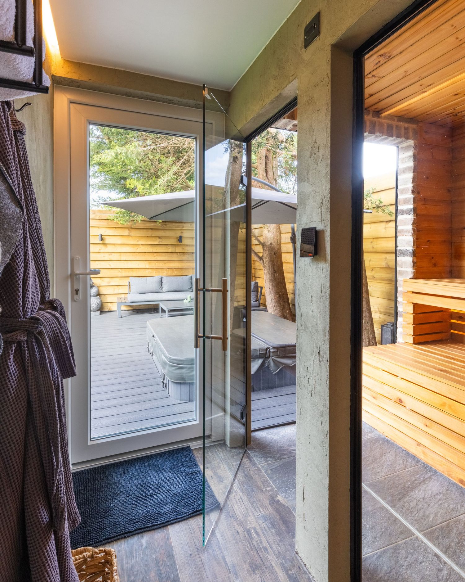 Modern spa bathroom in Bedfordshire with glass shower, sauna room and access to outdoor decking, shot as part of an interior photoshoot.