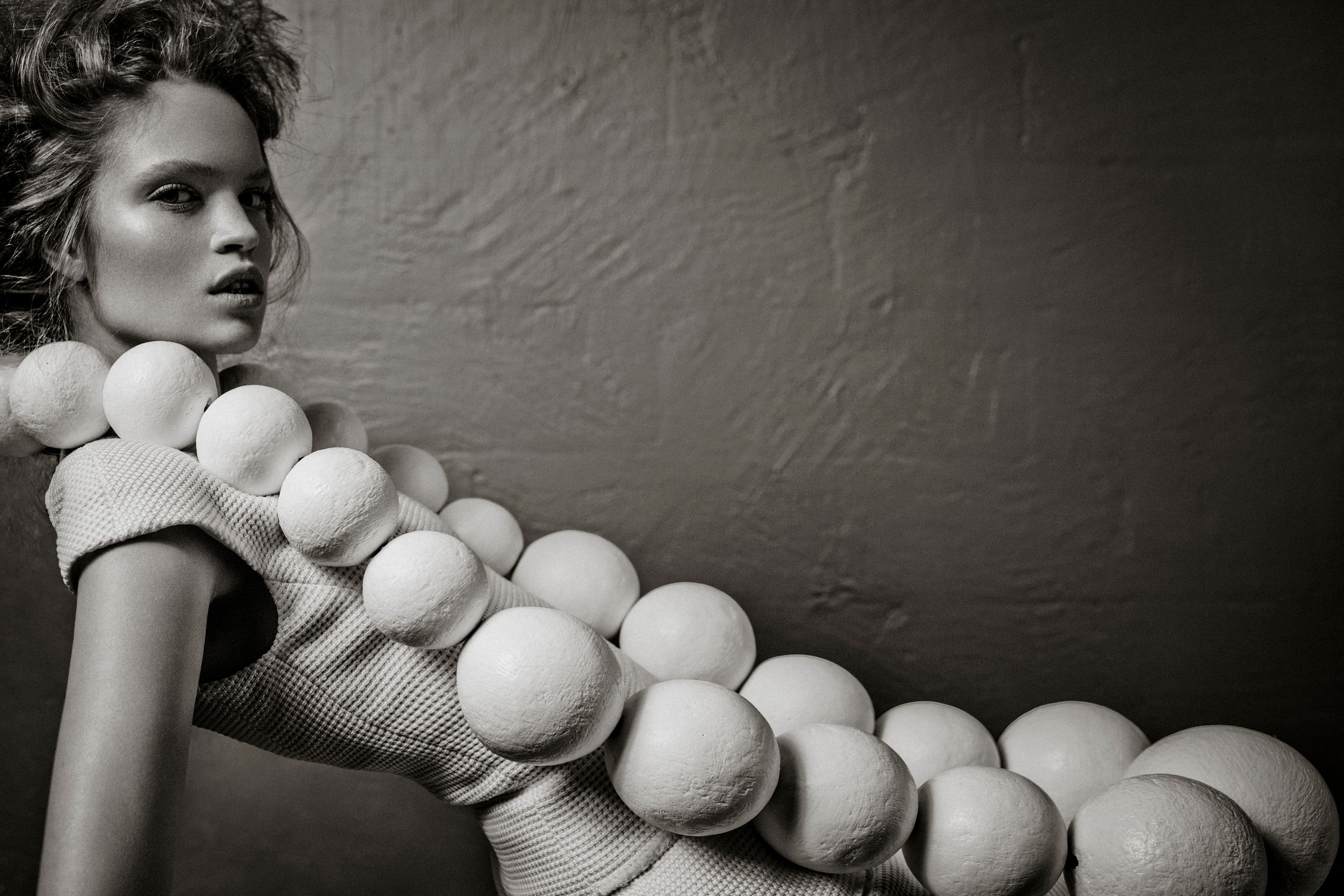 Black and white fashion photo of a model wearing an avant-garde bubble sphere sculptural dress design.