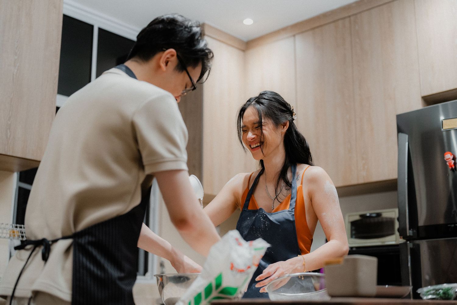 Couple having fun while cooking and baking together in their home kitchen.