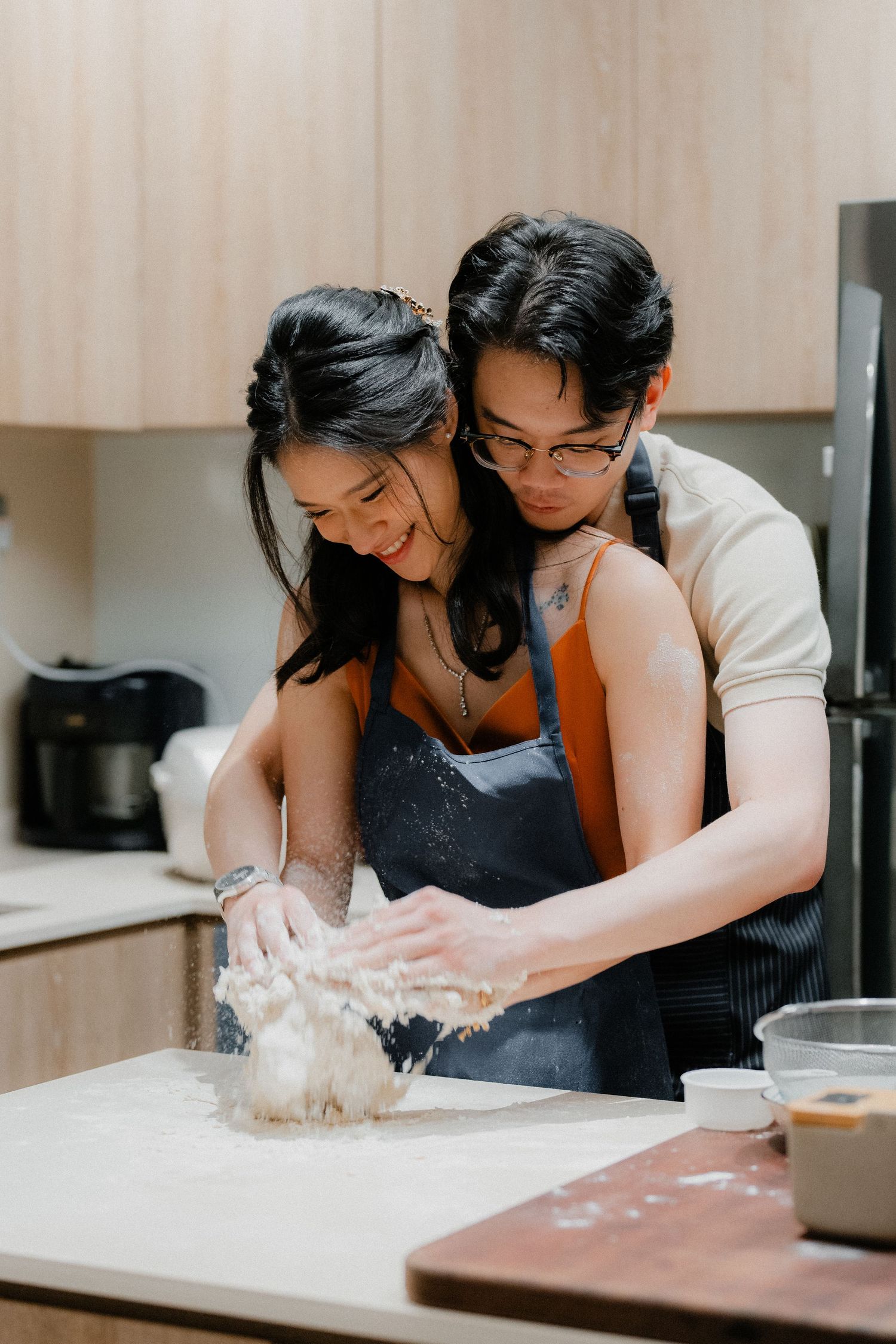 Intimate cooking moment as couple makes dough together in kitchen.