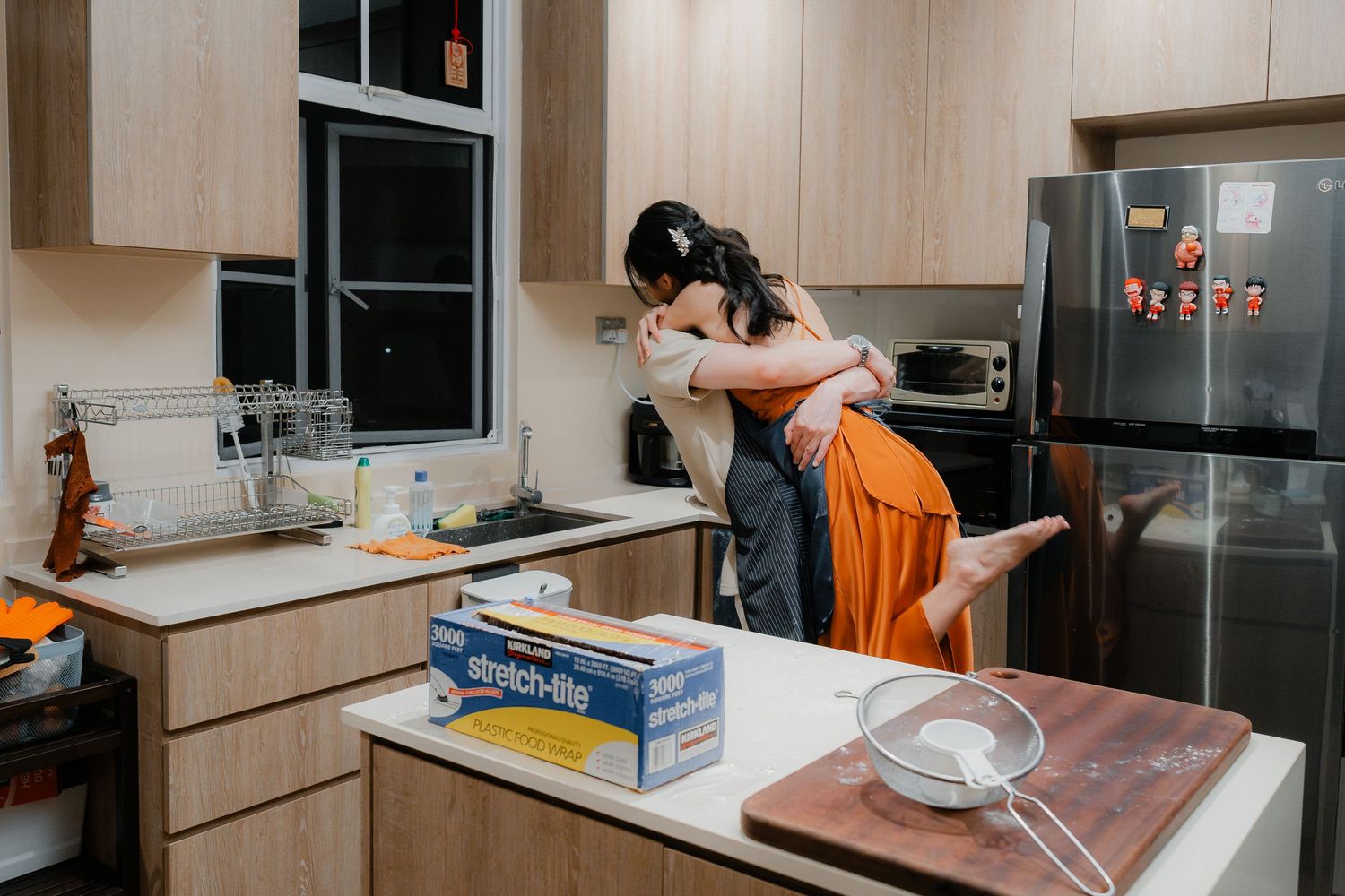 Romantic embrace in modern kitchen while cooking together.