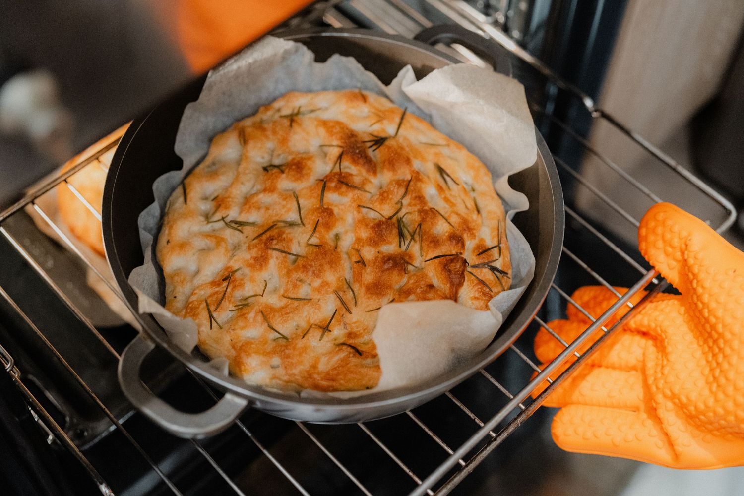 A golden brown baked pie with lattice crust cooling in a cast iron skillet.
