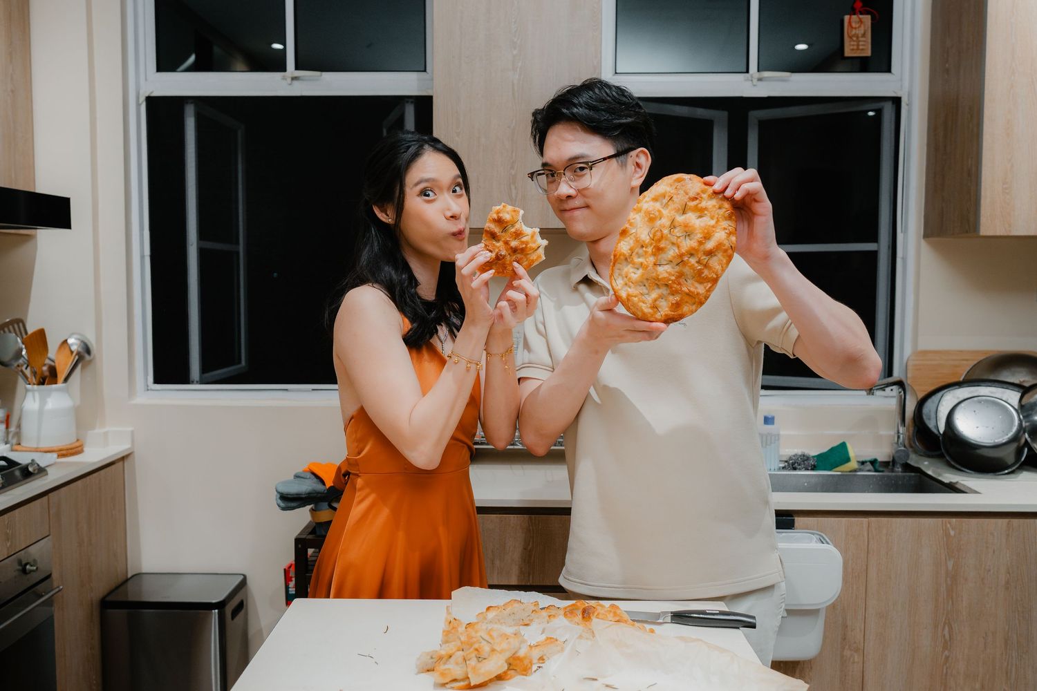 Two people enjoying freshly baked pie together in their kitchen.