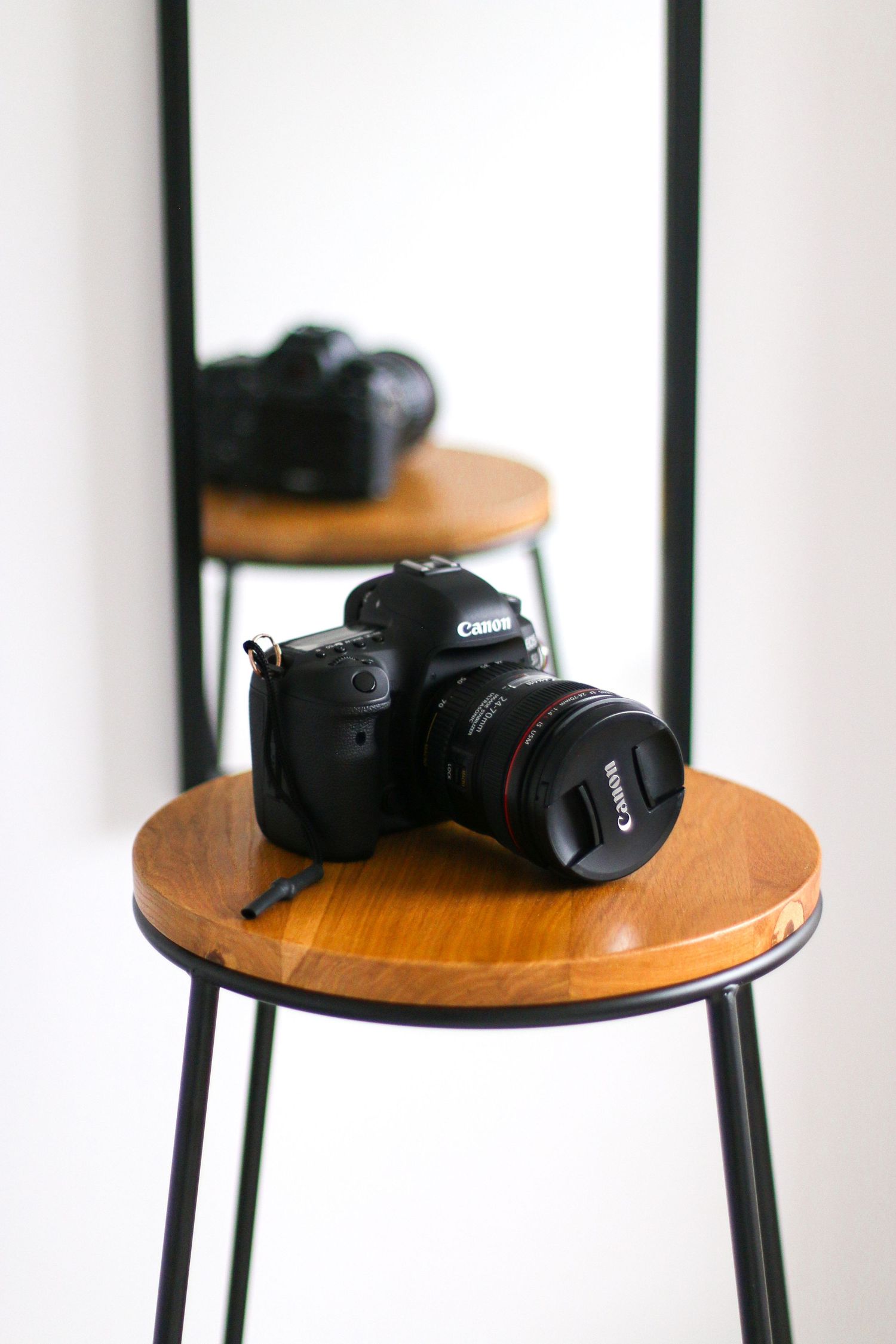 Camera displayed on wooden circular stools against a white background Nottingham photography studio