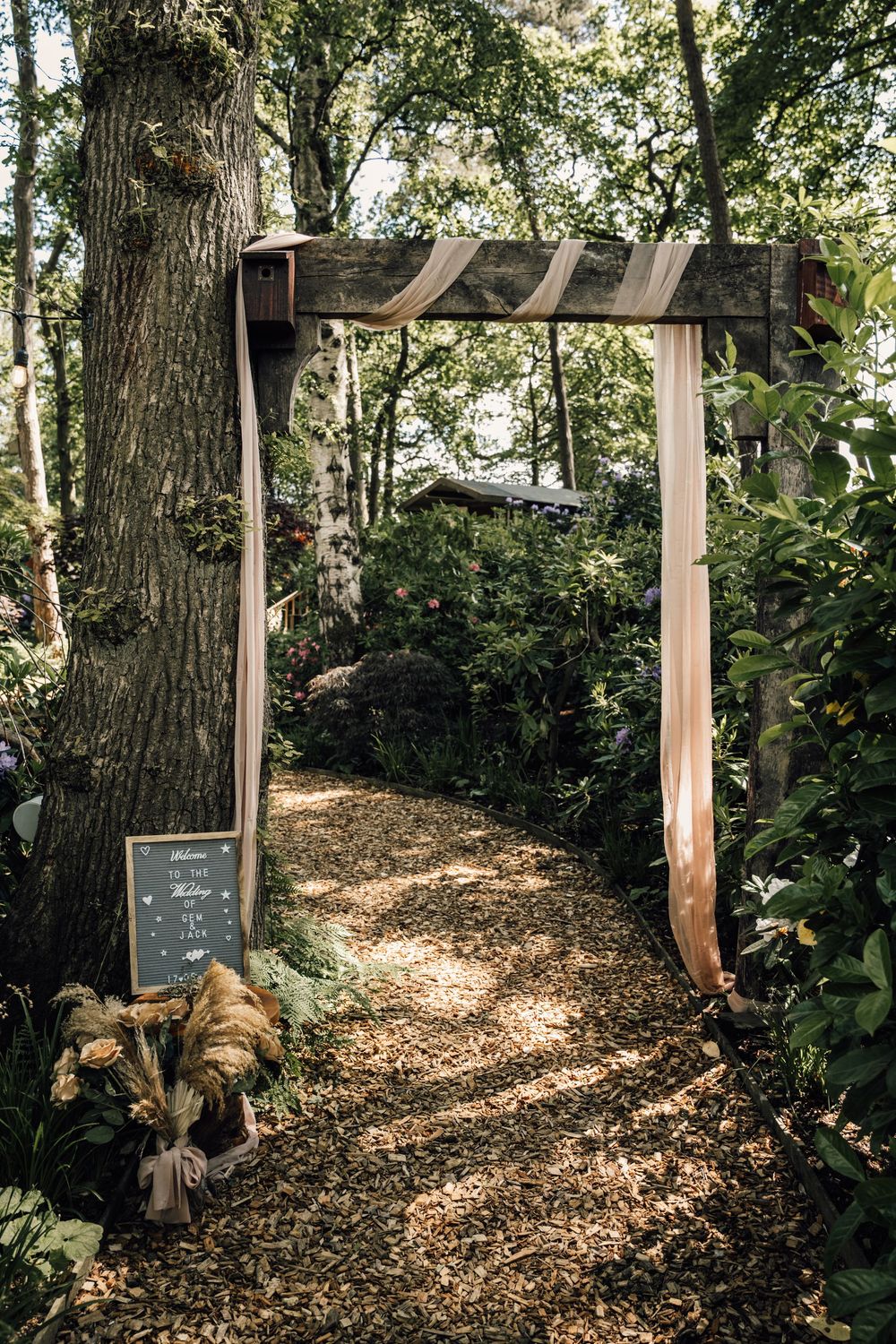 A rustic woodland path with mulch ground cover and wooden posts creating an enchanting outdoor walkway.
