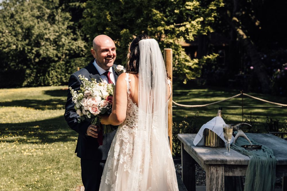 Outdoor wedding ceremony with elegant white dress and floral arrangements.