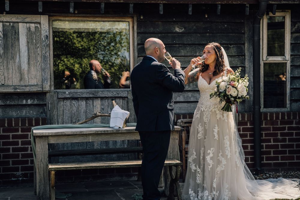 Wedding celebration outside a rustic brick building with formal attire.