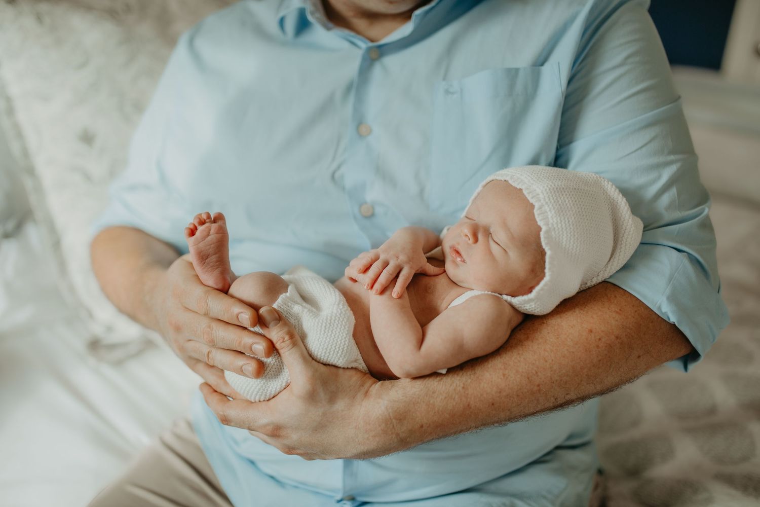 Close-up of parent holding newborn’s head during a natural in-home baby session in Bromley