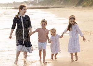 Happy family splashing and playing in the ocean waves at the beach.