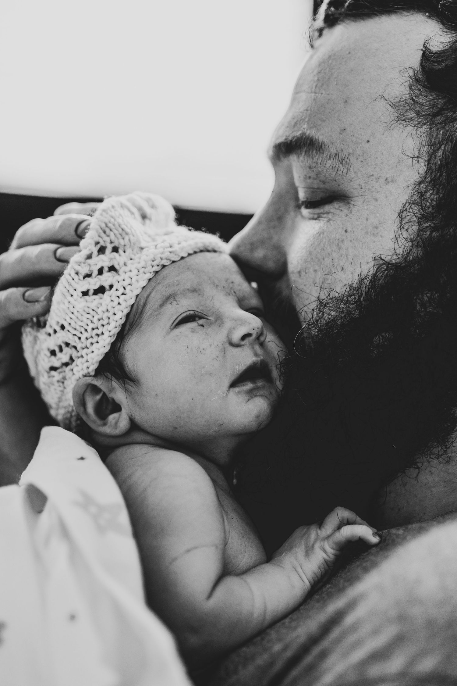 Father holds his first son during the birth and holds him close