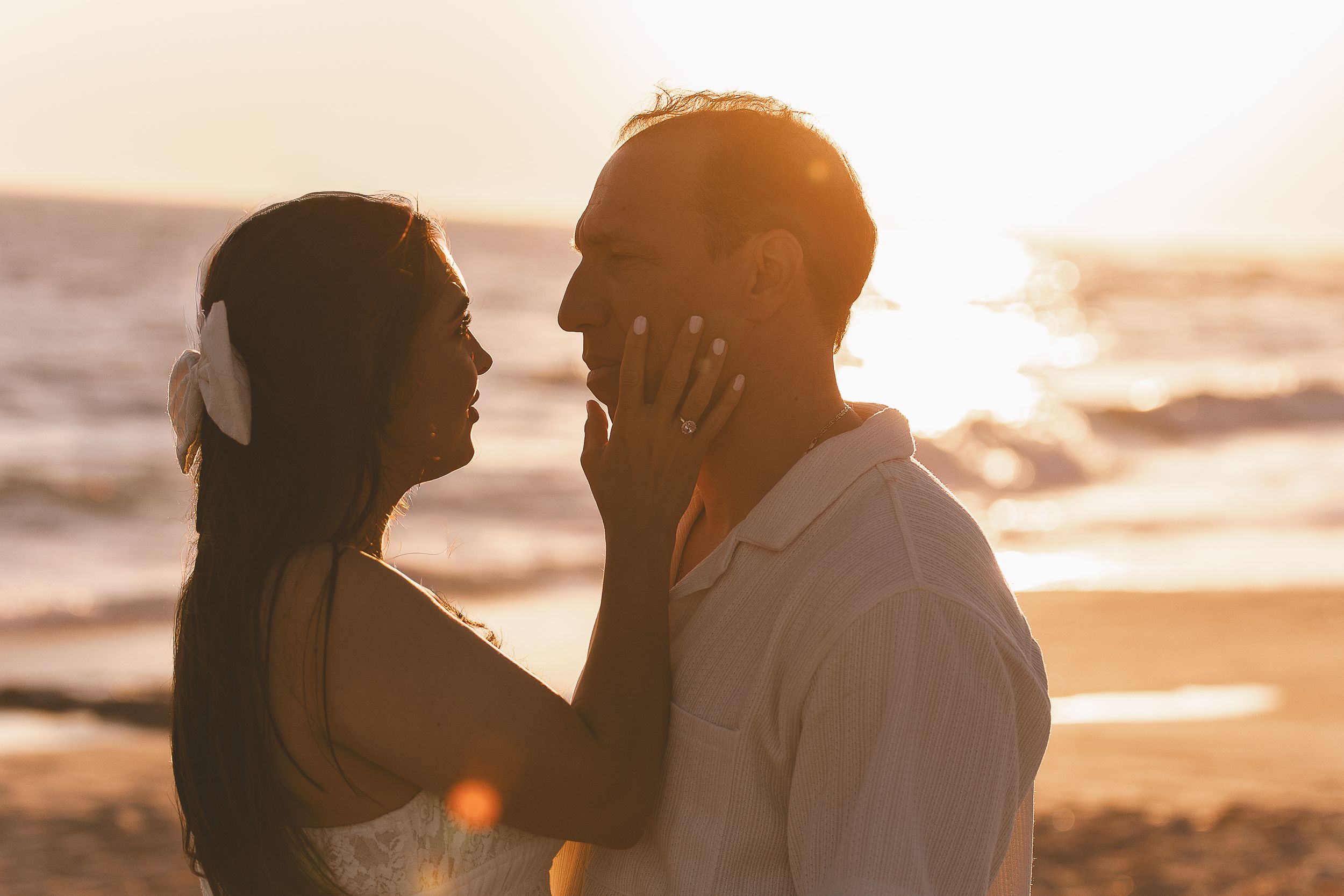 A romantic silhouette of a couple embracing at sunset on the beach.