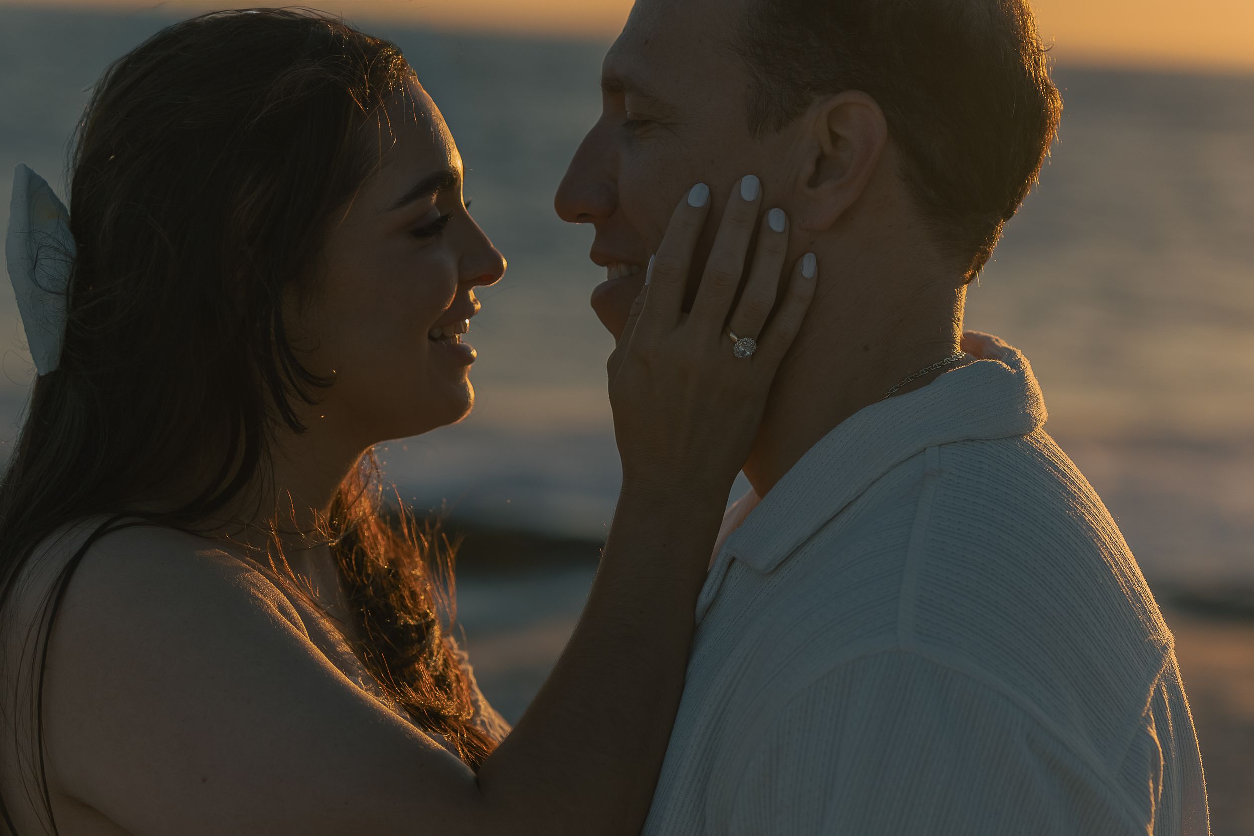 Silhouettes of a couple in an intimate moment against a golden sunset backdrop.