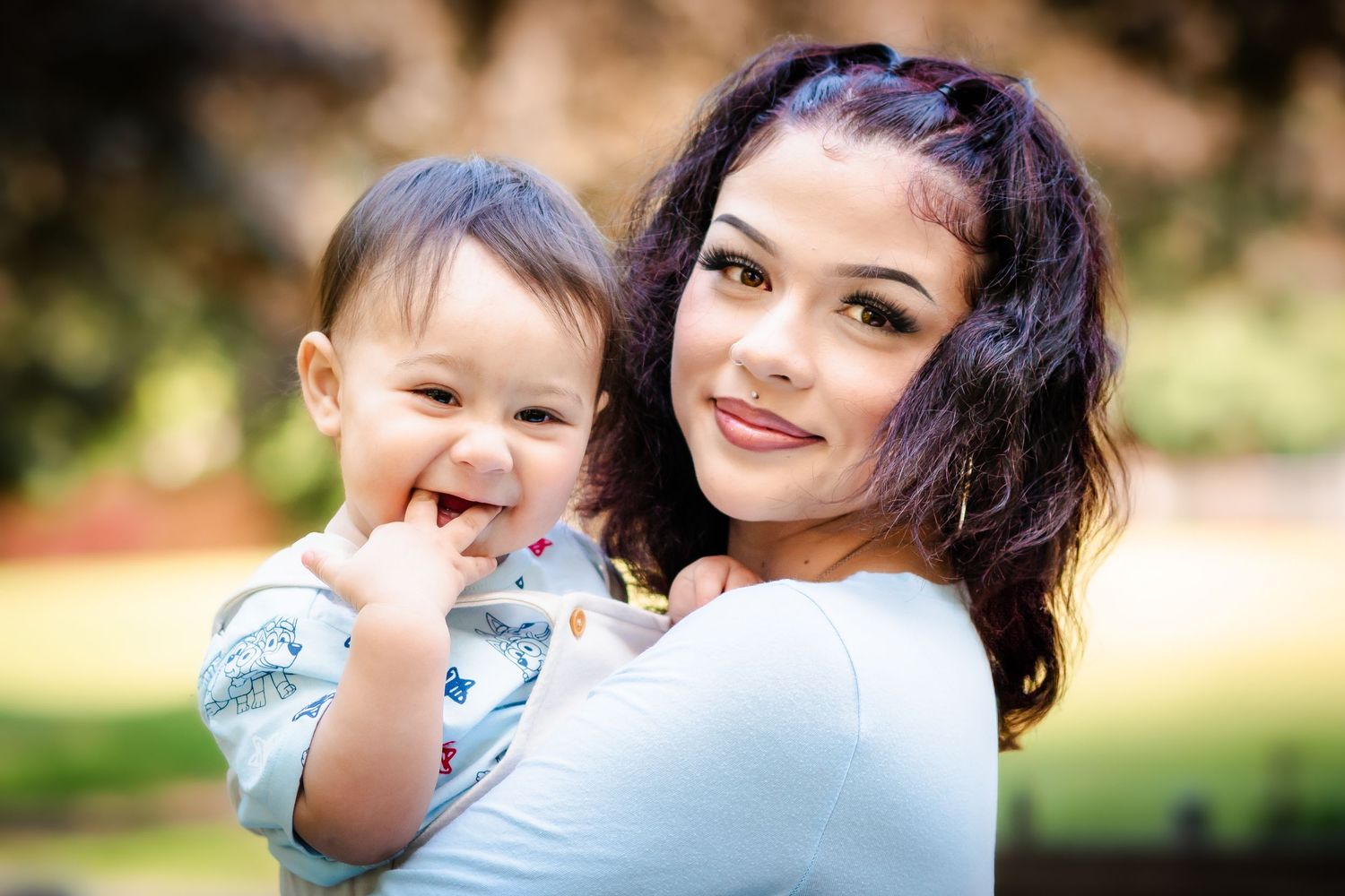 Candid outdoor portrait in natural lighting with soft bokeh background.