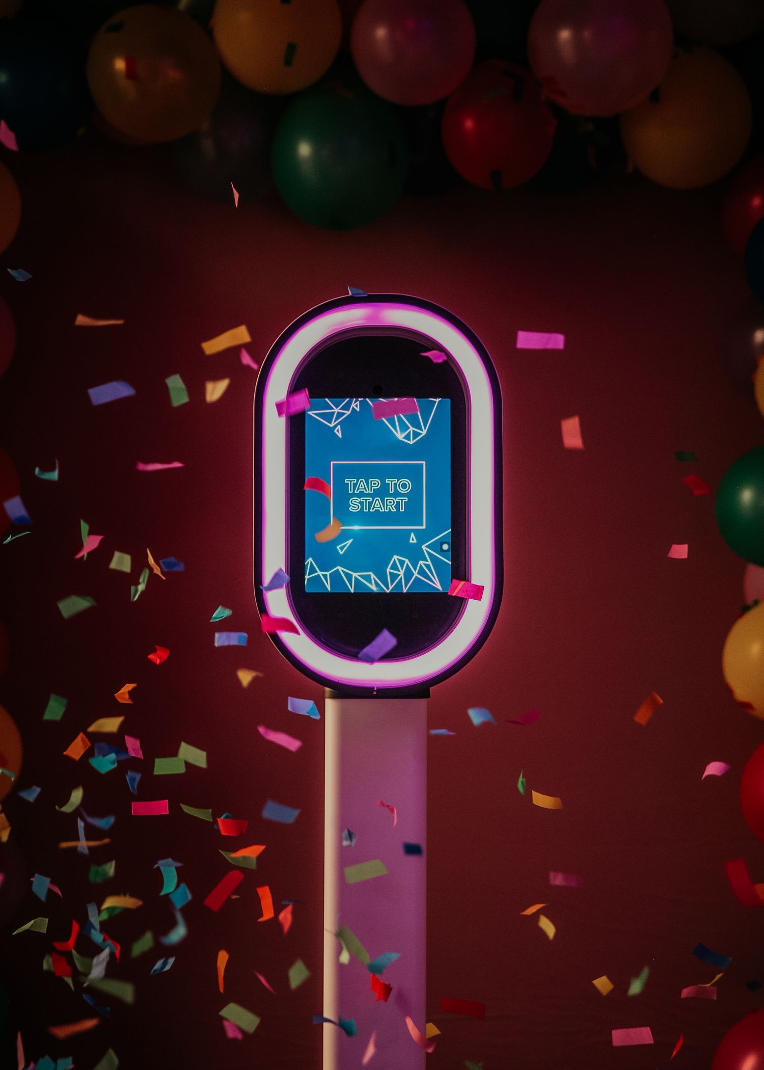Colorful confetti falls against a dark red background as a neon circle light glows with text fragments visible through motion.