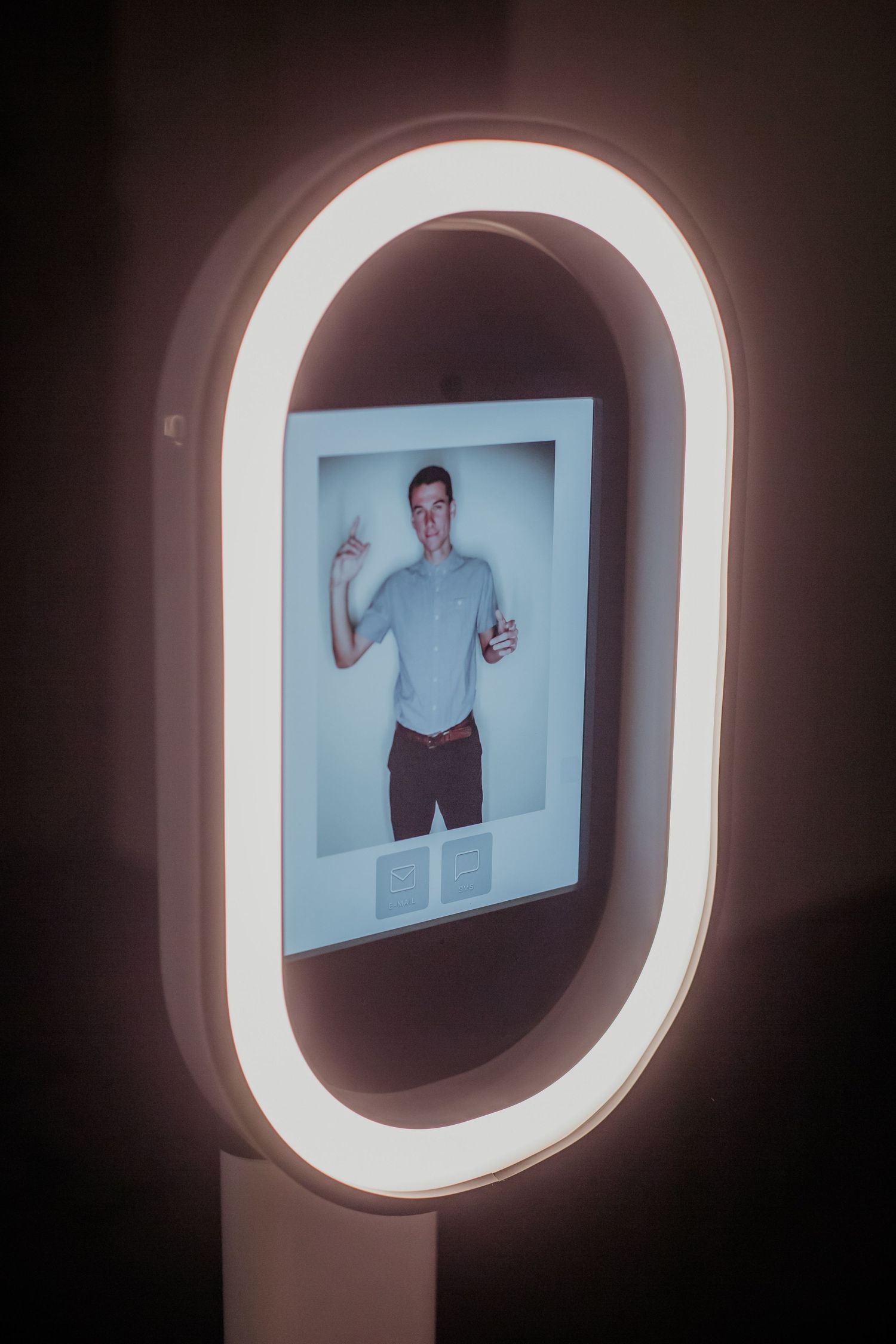 A digital photo displayed within an illuminated oval-shaped LED frame creates a modern technological display effect.