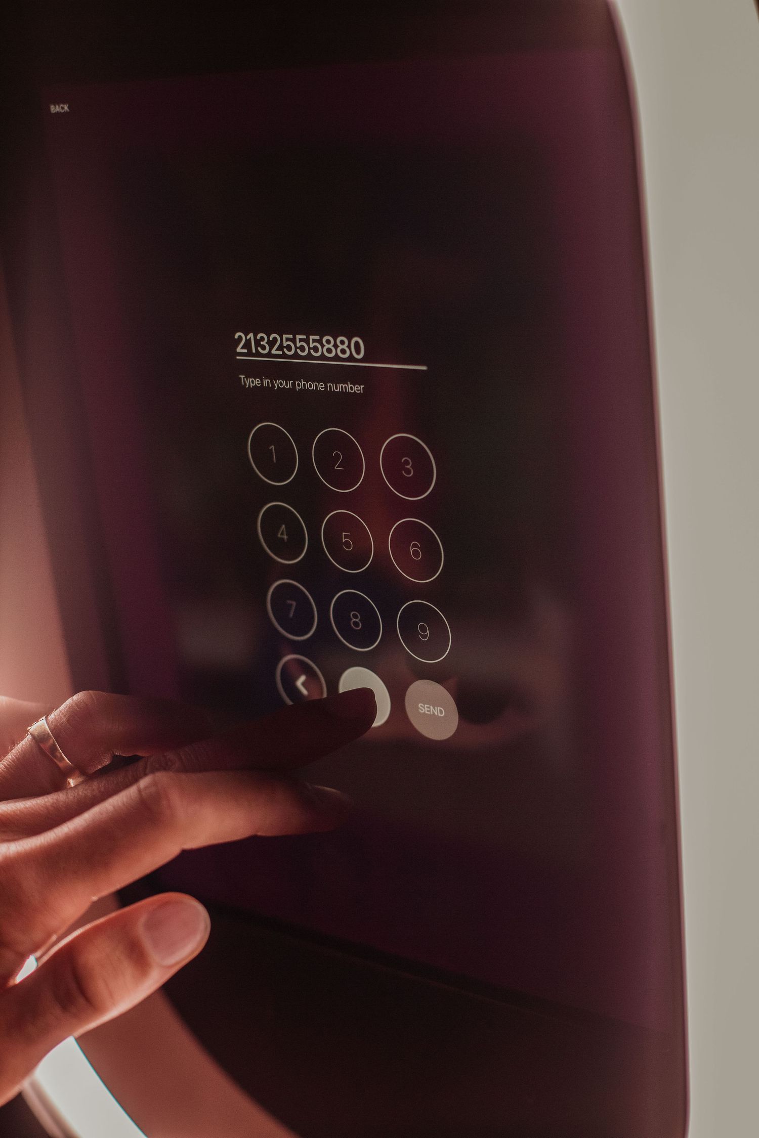 A hand reaching to enter a numerical code on a digital keypad display with glowing numbers.