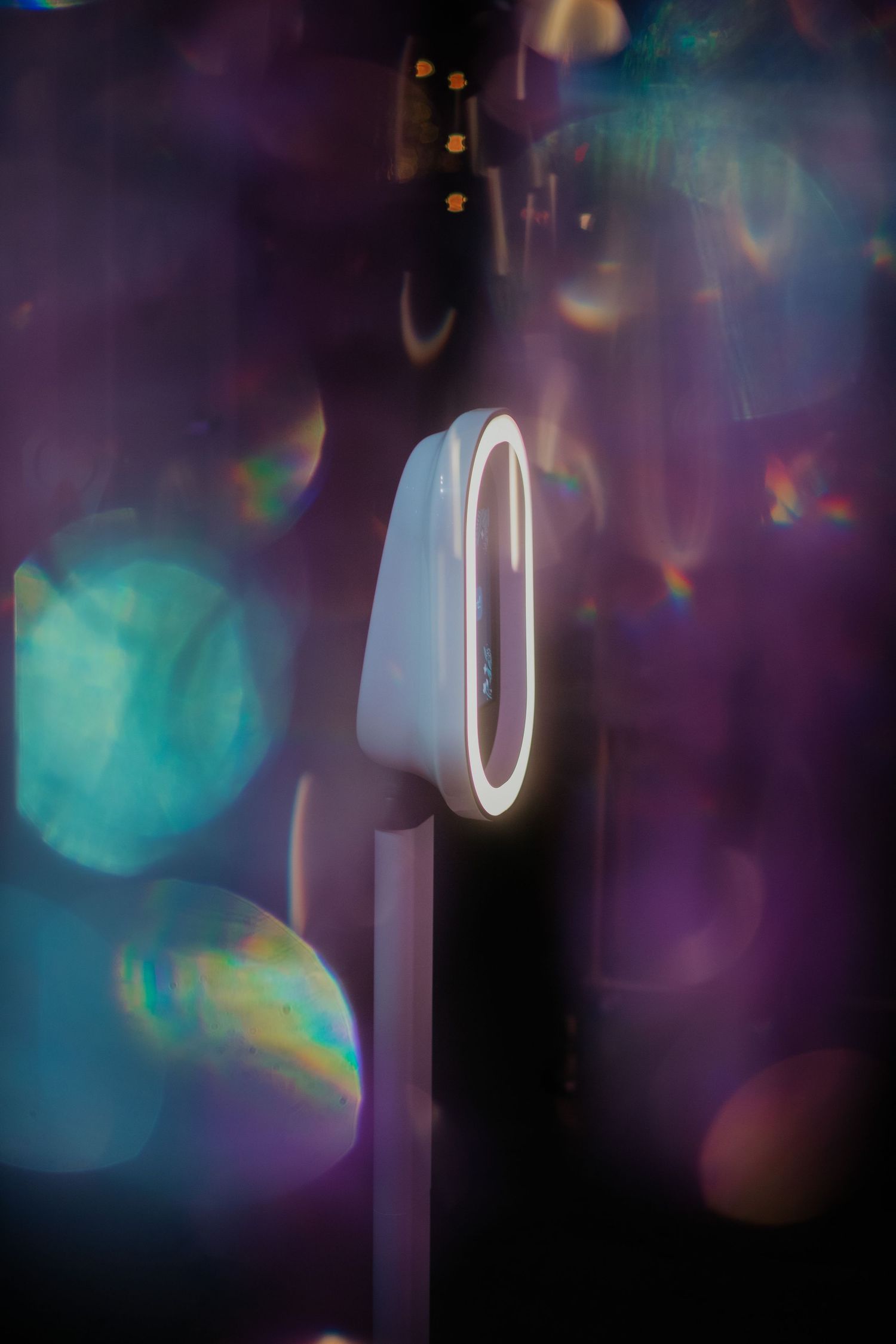 A glowing white number zero against a dark background with blurred blue and purple bokeh light effects.