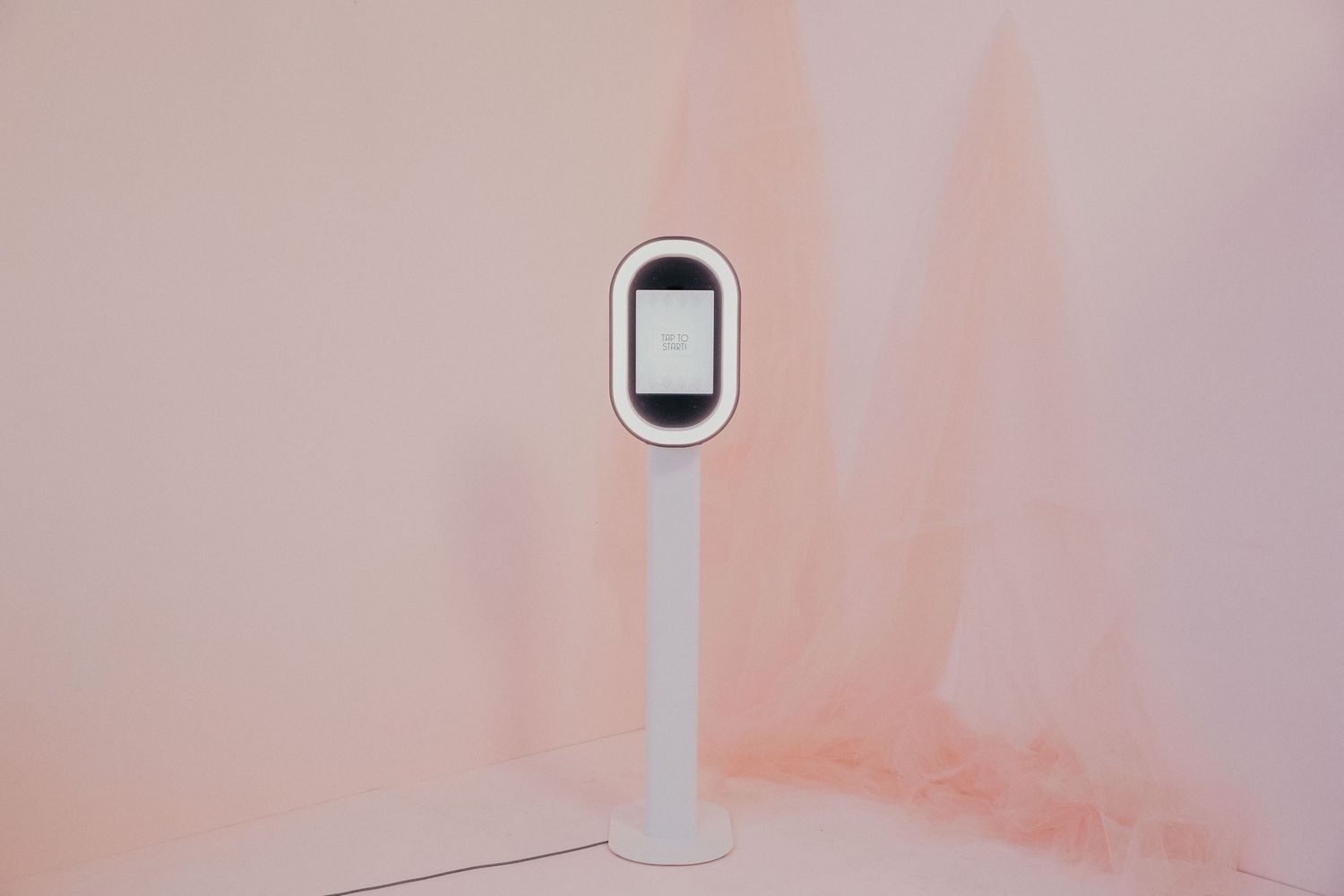 Contemporary minimalist white doorbell camera installed on a pink wall with neutral lighting.
