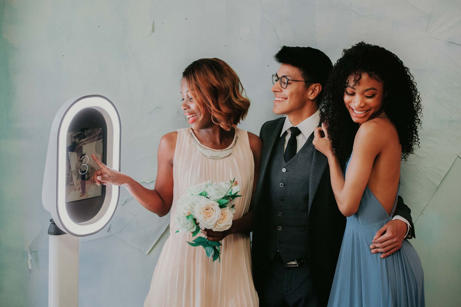 Three wedding guests look through an airplane window together while sharing a joyful moment during the flight.