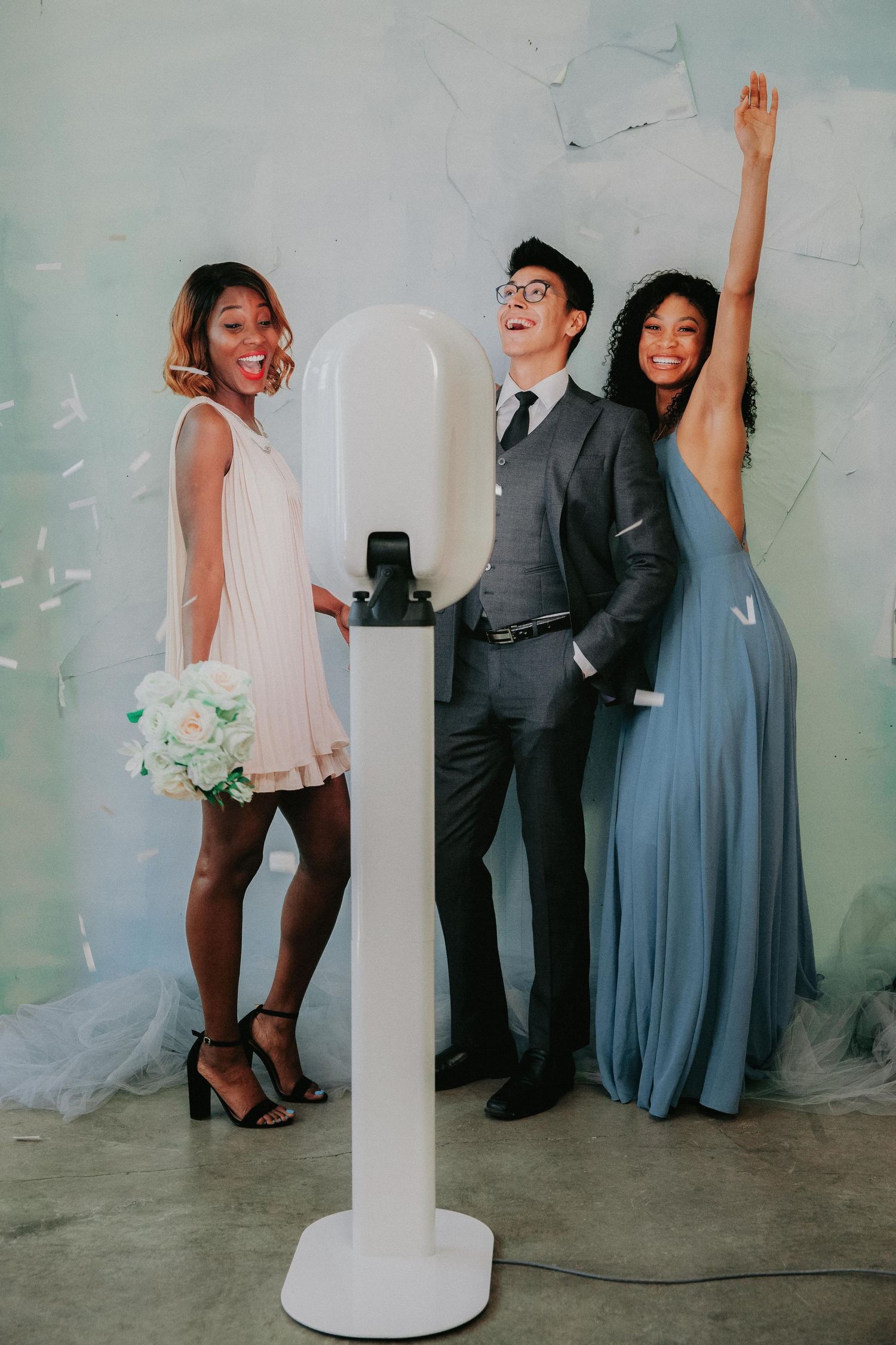 A series of photos showing people in formal wear posing playfully against a light-colored wall during a wedding celebration.