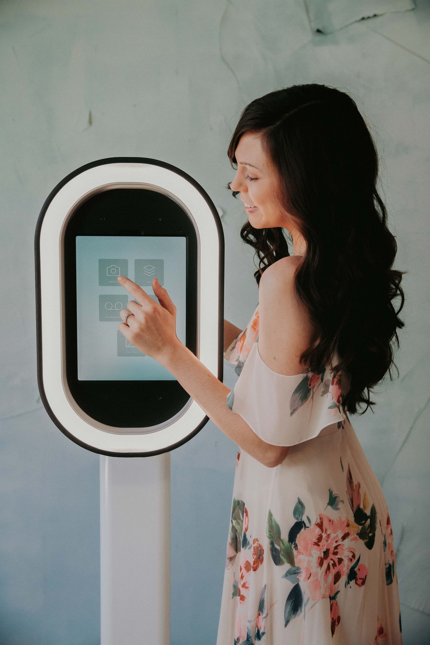 A sequence of photos showing a person in a floral dress looking through a round porthole-style window against a white wall.