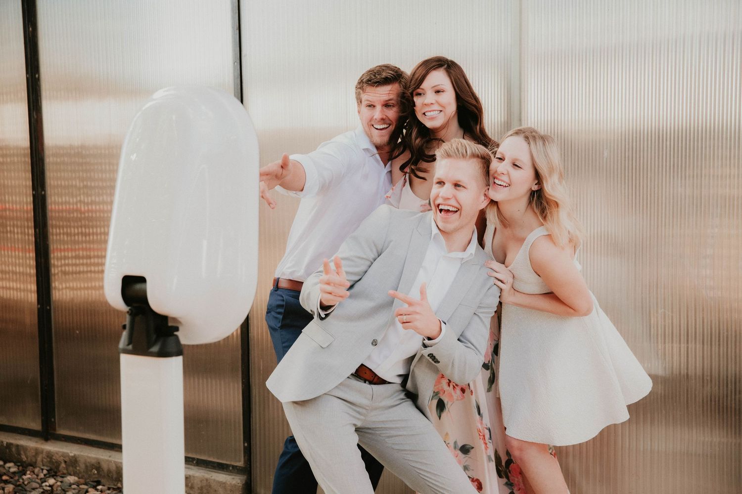 A joyful group gathers around a photo booth setup with a white light ring for playful portraits.