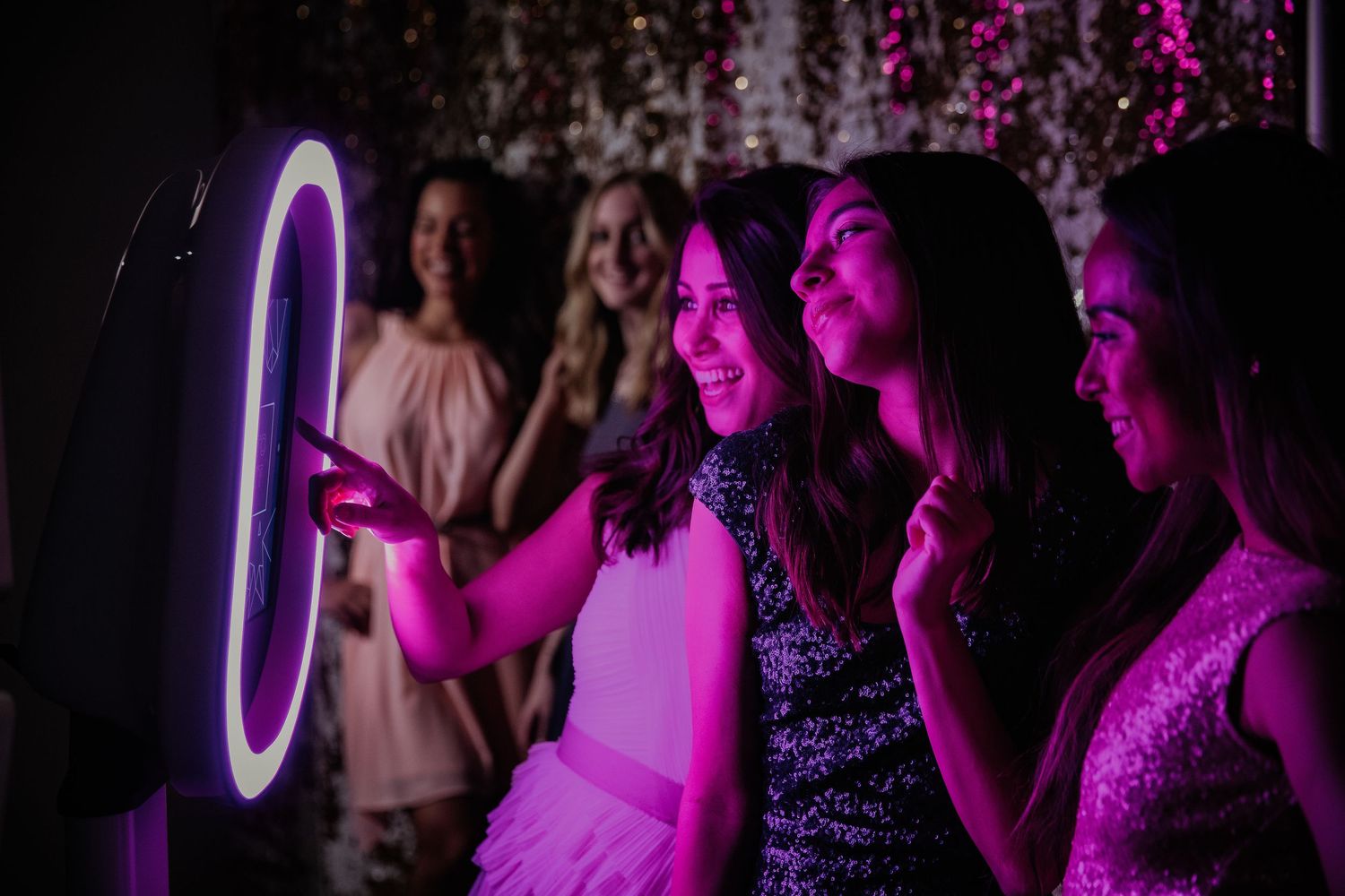 People enjoy a nightclub party with purple lighting creating a vibrant dance floor atmosphere.