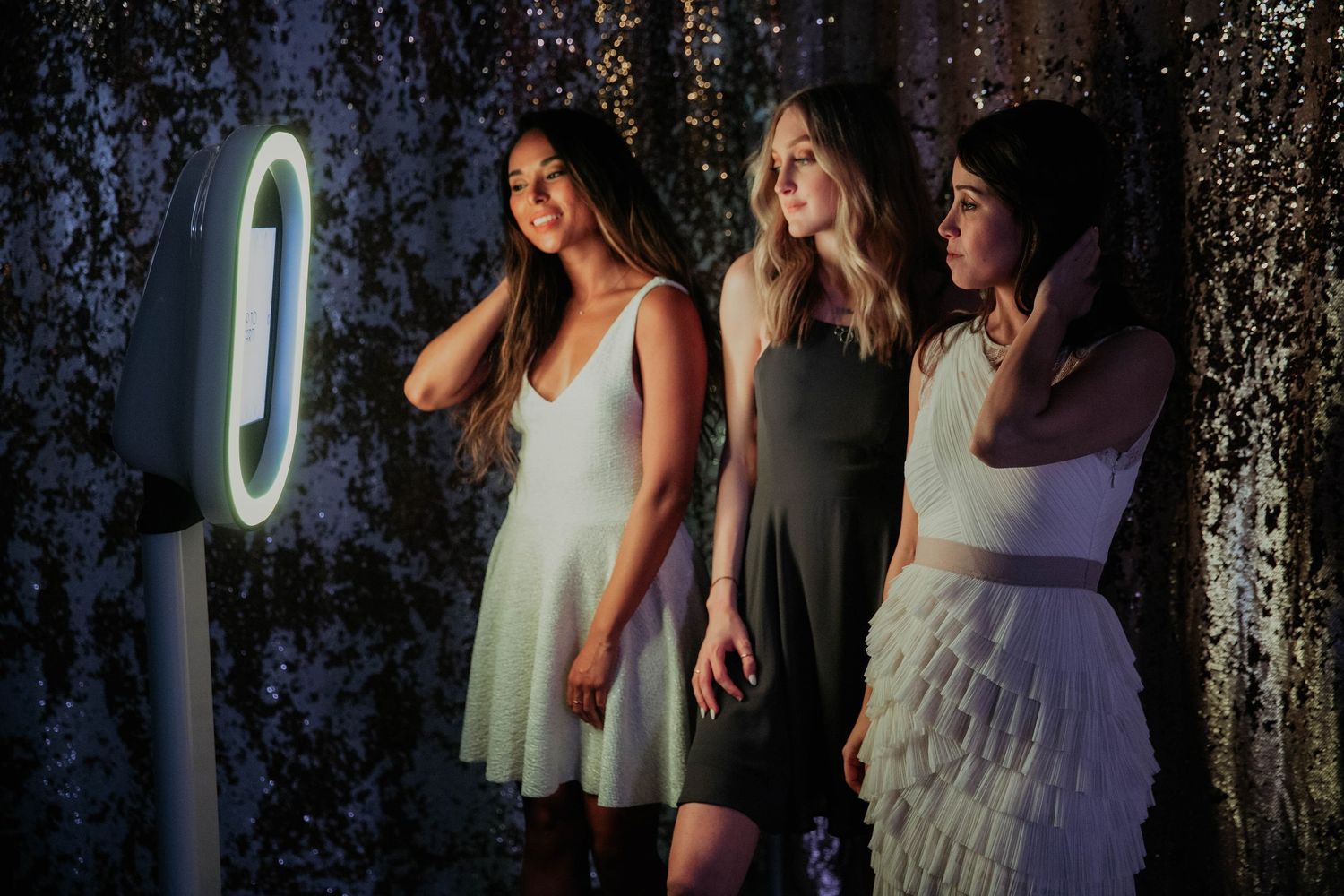 A cinematic group photo at a celebration with people in formal attire posed against a sparkly backdrop.