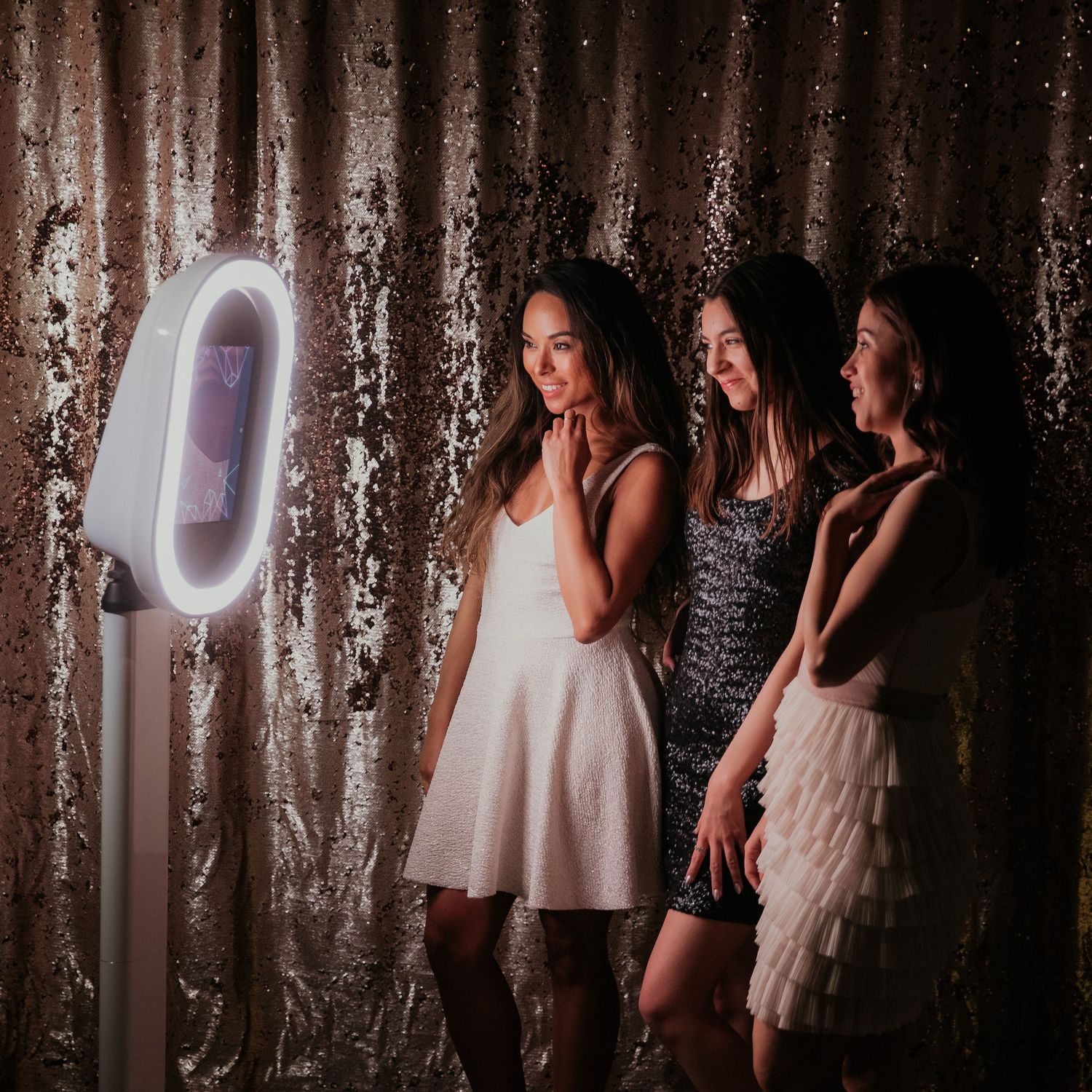 Festive shimmering backdrop captures playful silhouettes of people dancing and posing in a dimly lit party atmosphere.