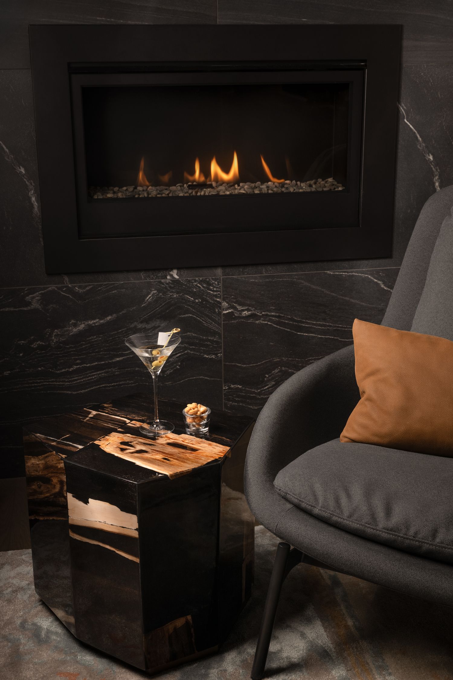 Modern living room interior with sleek marble decor and glowing fireplace creates an elegant ambiance.