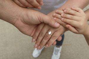 Close-up of hands showing engagement or wedding rings.