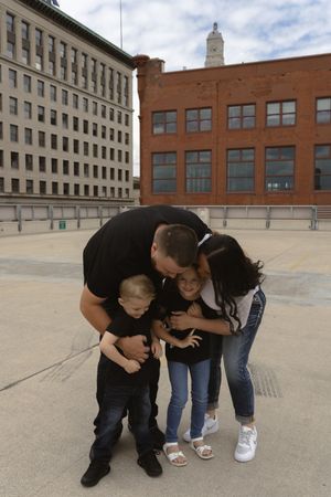 A family group huddled together sharing a playful moment on an urban rooftop.