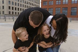 A family group sharing an affectionate moment together on a rooftop.