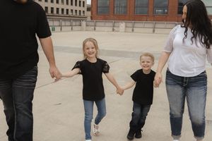 Group walking and playing together on a concrete rooftop with city buildings visible.