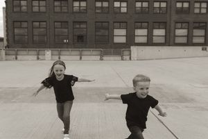 People playing and running on an urban rooftop with architectural elements visible.
