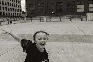 Group enjoying playful moments on a concrete rooftop surrounded by city buildings.