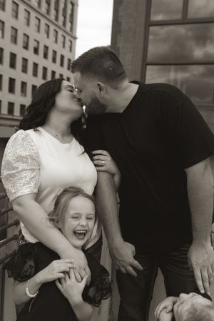 Candid black and white series showing a family laughing and embracing together.