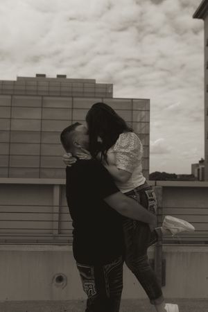 Two people hugging and spinning joyfully on an urban rooftop.